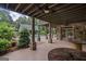 Covered outdoor patio features stone columns, ceiling fans, and a view of the pool and landscaped yard at 1385 Gordon Rd, Moreland, GA 30259
