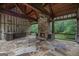 Covered outdoor living area with stone fireplace, built-in kitchen, and flagstone flooring at 1385 Gordon Rd, Moreland, GA 30259
