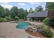 Resort-style pool with a rock waterfall feature and adjacent pool house, surrounded by lush greenery at 1385 Gordon Rd, Moreland, GA 30259