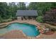Aerial view of a backyard pool and spa with waterfall features, adjacent to an outdoor pool house at 1385 Gordon Rd, Moreland, GA 30259