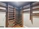 A spacious walk-in closet featuring wooden shelving, hanging racks, and wood flooring at 1385 Gordon Rd, Moreland, GA 30259