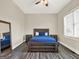 Cozy bedroom with a wooden bed frame, plush blue bedding, and wood-look tile flooring at 340 Cedar St, Social Circle, GA 30025