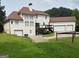 Spacious backyard featuring a well-kept lawn, deck, and three-car garage at 130 Victoria Pl, Fayetteville, GA 30214