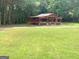 Spacious backyard featuring a covered outdoor entertainment area and lush green grass at 130 Victoria Pl, Fayetteville, GA 30214