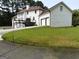 Backyard view of a spacious home with a lawn, deck, and three-car garage at 130 Victoria Pl, Fayetteville, GA 30214
