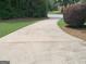 Wide, curved driveway leads to a home nestled amidst lush greenery at 130 Victoria Pl, Fayetteville, GA 30214