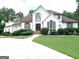 Stately home featuring a well-manicured lawn, sculpted bushes, and a private driveway at 130 Victoria Pl, Fayetteville, GA 30214