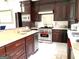 Gourmet kitchen with stainless steel appliances, custom cabinets, and quartz countertops at 130 Victoria Pl, Fayetteville, GA 30214