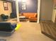 A chic living room with stylish decor, featuring a comfortable orange sofa and modern furniture at 130 Victoria Pl, Fayetteville, GA 30214