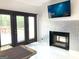 Open living room with modern fireplace, French doors, and marble floors at 130 Victoria Pl, Fayetteville, GA 30214