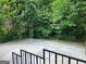Backyard featuring a large concrete pad and mature foliage at 615 Cofield Dr, Hapeville, GA 30354