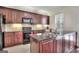 Kitchen with dark cherry-stained cabinets, granite countertops, and tiled backsplash at 2804 Dominion Nw Ln # Bldg 2, Kennesaw, GA 30144