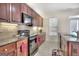 Kitchen with dark cherry-stained cabinets, granite countertops, and tiled backsplash at 2804 Dominion Nw Ln # Bldg 2, Kennesaw, GA 30144