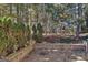 Serene outdoor patio area with a stone retaining wall, trees, and landscaping for privacy at 2804 Dominion Nw Ln # Bldg 2, Kennesaw, GA 30144