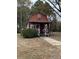 Red barn style home with a covered porch, shrubbery, and a sidewalk at 10142 Washington Street, Covington, GA 30014