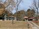 Street view of two homes on a treed lot with driveway and signage at 10142 Washington Street, Covington, GA 30014