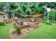 Backyard deck with hot tub surrounded by landscaped garden features overhead shade and privacy fence at 55 Ashton Pl, Covington, GA 30016
