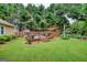 Backyard deck features a built-in hot tub, a cozy seating area, and surrounding landscaping for an enjoyable retreat at 55 Ashton Pl, Covington, GA 30016