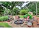 A backyard area featuring a fire pit with seating surrounded by lush greenery and a serene setting at 55 Ashton Pl, Covington, GA 30016