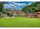Lush green backyard with a patio area, wooden deck, and ample space for recreation and relaxation at 55 Ashton Pl, Covington, GA 30016