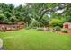 Spacious backyard featuring a lush lawn, fire pit area, garden shed, and surrounding mature trees for privacy at 55 Ashton Pl, Covington, GA 30016