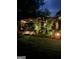 Backyard at dusk featuring a covered patio and grilling area with landscape lighting and plants at 55 Ashton Pl, Covington, GA 30016