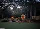 Backyard at dusk featuring a shed, a fire pit with chairs, and landscape lighting at 55 Ashton Pl, Covington, GA 30016