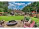 Spacious backyard featuring a fire pit, seating area, and well-maintained lawn, perfect for outdoor entertaining at 55 Ashton Pl, Covington, GA 30016