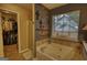 Bathroom view of a soaking tub, unique wood paneling, adjacent closet, and natural light at 55 Ashton Pl, Covington, GA 30016