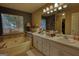 Bathroom featuring double sinks, a large soaking tub, and stylish fixtures, designed for relaxation at 55 Ashton Pl, Covington, GA 30016