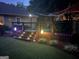 Wooden deck at dusk with multiple levels, landscape lighting, plants, and lounge furniture at 55 Ashton Pl, Covington, GA 30016