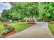 Spacious yard with mature trees, lush landscaping, and a paved driveway leading to the residence at 55 Ashton Pl, Covington, GA 30016