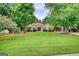 Inviting home featuring a well-manicured lawn, mature trees, and charming curb appeal at 55 Ashton Pl, Covington, GA 30016