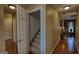 Hallway with neutral paint, wood floors, and doorways leading to various rooms, providing seamless flow throughout the home at 55 Ashton Pl, Covington, GA 30016
