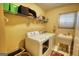 Clean and functional laundry room with a washing machine, dryer, and a utility sink at 55 Ashton Pl, Covington, GA 30016