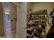 Walk-in closet featuring a shelving unit stocked with shoes, with a glimpse of the bathroom next door through an open door at 55 Ashton Pl, Covington, GA 30016