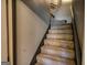 Carpeted staircase featuring neutral paint on the walls and a handrail for safety and support, leading to upper level at 55 Ashton Pl, Covington, GA 30016