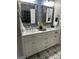Bathroom with double vanity, marble countertop, decorative mirrors, and patterned tile floor at 90 Barrington Grange Dr, Sharpsburg, GA 30277