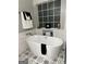 Elegant freestanding tub with sleek fixtures and decorative tile flooring at 90 Barrington Grange Dr, Sharpsburg, GA 30277