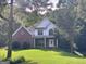 Charming two-story brick home with a well-manicured front lawn and lush landscaping at 90 Barrington Grange Dr, Sharpsburg, GA 30277