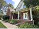 Inviting covered front porch with brick steps, columns, and decorative door at 90 Barrington Grange Dr, Sharpsburg, GA 30277
