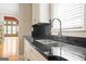 Close-up of kitchen sink with granite counters and view to the open concept living area in the distance at 3451 Fairway Dr, College Park, GA 30337