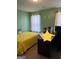Comfortable bedroom with green walls, complete with a desk, personal computer, and a yellow quilt at 301 Leland Ct, Mcdonough, GA 30253
