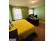 Comfortable bedroom with green walls, complete with a desk, personal computer, and a yellow quilt at 301 Leland Ct, Mcdonough, GA 30253