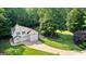 Stunning aerial view of a farmhouse with a three-car garage on a sprawling, wooded lot at 654 Cannon Rd, Sharpsburg, GA 30277