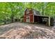 Rustic red barn with a large door and lean-to style additions surrounded by trees at 654 Cannon Rd, Sharpsburg, GA 30277