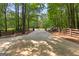 Long driveway leads to an ornate iron gate with a wood fence on a tree-lined property at 654 Cannon Rd, Sharpsburg, GA 30277
