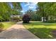 Long, curved driveway approaching a charming house with vibrant green landscaping at 654 Cannon Rd, Sharpsburg, GA 30277