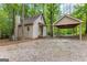 Charming home with a gravel driveway and a carport nestled among mature trees at 654 Cannon Rd, Sharpsburg, GA 30277