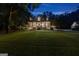 Elegant two-story home with a large front porch, brick accents, and lush landscaping at twilight at 654 Cannon Rd, Sharpsburg, GA 30277